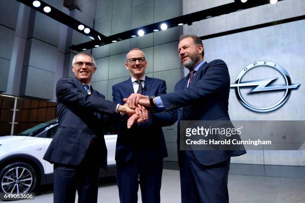 Carlos Tavares, Opel CEO Karl-Thomas Neumann and GM President Dan Ammann shake hands during the Opel press conference as part of the 87th Geneva...