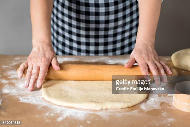 woman rolling dough with rolling pin in domestic kitchen - rolling pin photos et images de collection