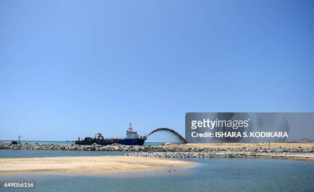 Dredger pumps sand to reclaim land just outside the port of Colombo on March 7 as part of a USD 1.4-billion real estate development by China. The...