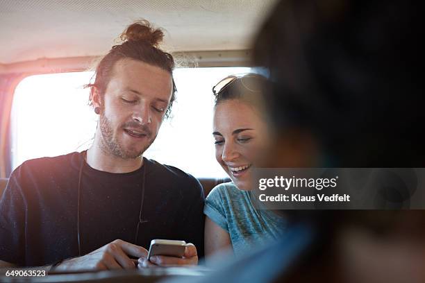 friends looking at phone, inside car - passengers 2016 film stock-fotos und bilder