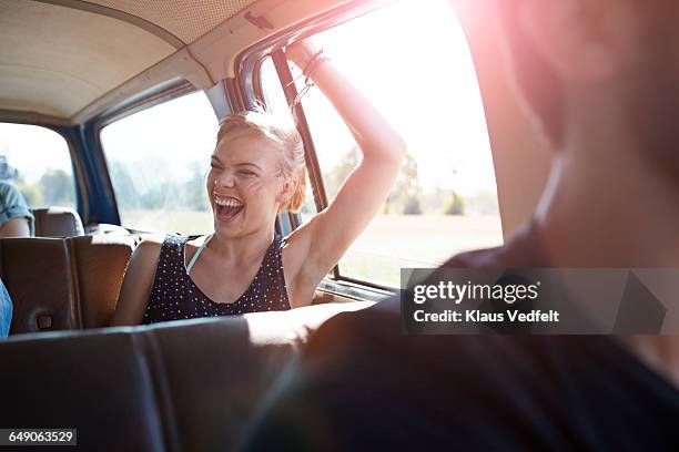 woman laughing while riding car - blonde youth culture stock pictures, royalty-free photos & images