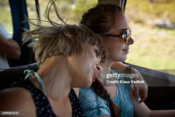 woman with arm around friend driving car - old car side view stock pictures, royalty-free photos & images