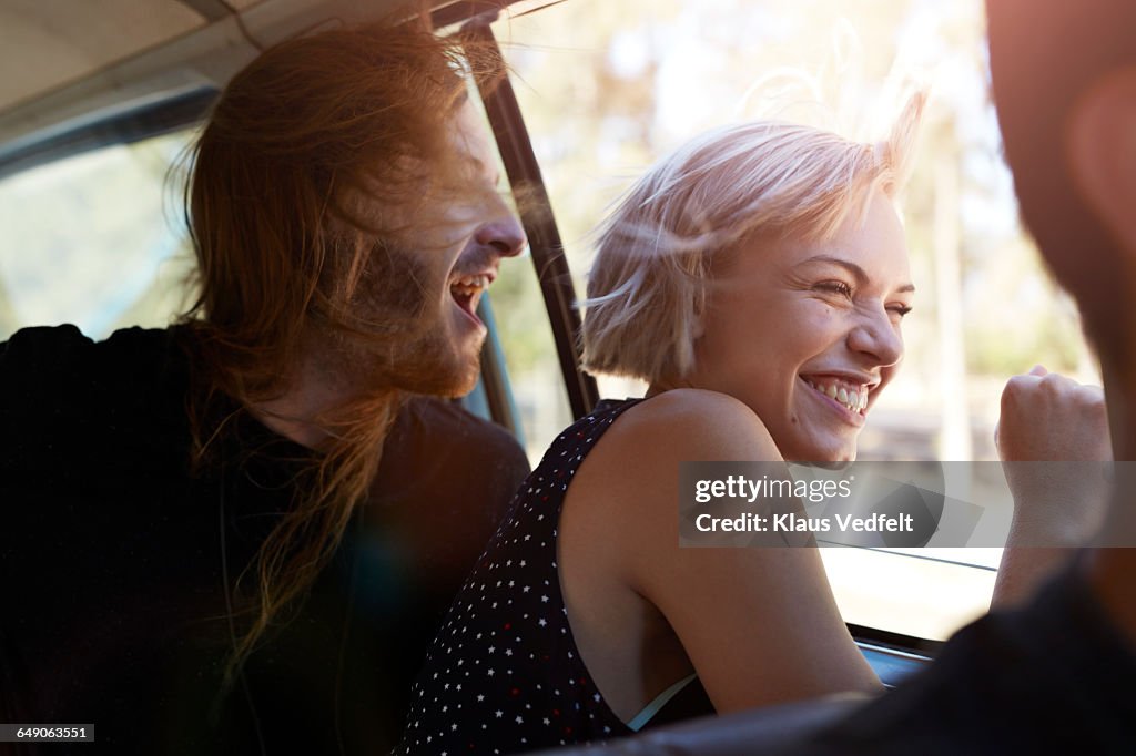 Friends laughing & looking out of window of car