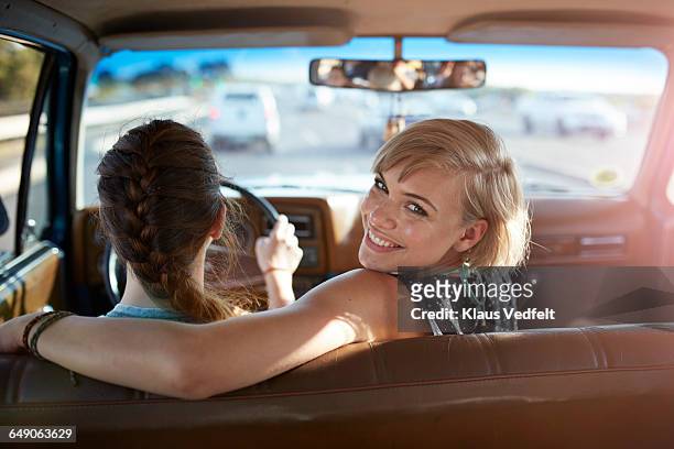 portrait of woman smiling while friend driving - old car interior stock pictures, royalty-free photos & images