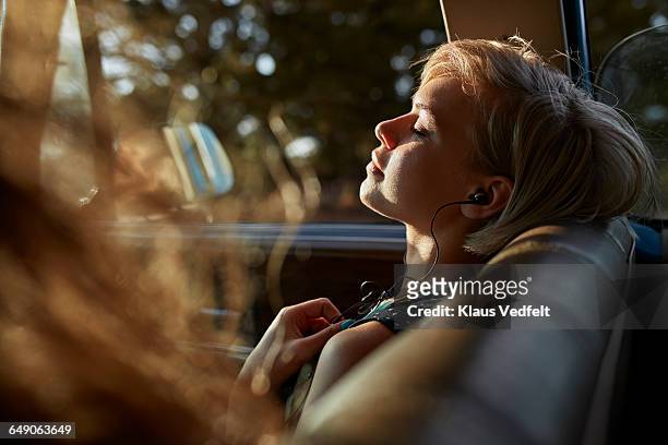 woman with headphones relaxing in car, at sunset - musica foto e immagini stock