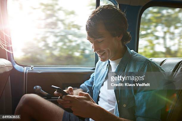 man looking at phone, while riding car - backseat bildbanksfoton och bilder
