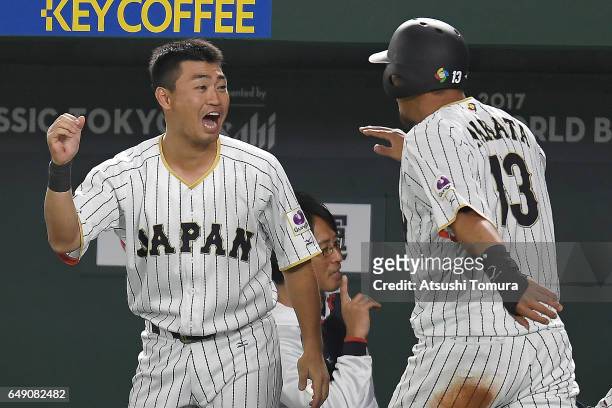 Sho Nakata of Japan celebrates with Norichika Aoki coming back home after Hayato Sakamoto of Japan hits a RBI double in the fifth inning of the World...