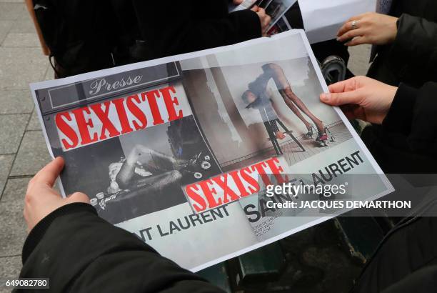 Picture taken during a demonstration in a Yves Saint-Laurent shop in Paris on March 7, 2017 shows a Effronte-e-s feminist movement's placard reading...