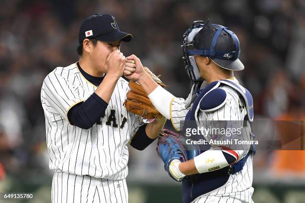 Pitcher Kazuhisa Makita of Japan celebrates with catcher Seiji Kobayashi of Japan after winning the World Baseball Classic Pool B Game One between...