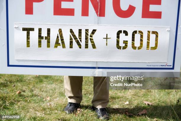 Supporter stands behind an altered Trump/Pence campaign sing as hundreds attend a Pro-Trump rally in Bensalem, PA, on March 4th, 2017. Similar small...