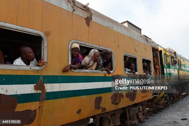 Passenger look out of the windows of a train at the Ebute-Metta headquarters of the Nigerian Railway Corporation in Lagos on March 7, 2017. Nigeria's...