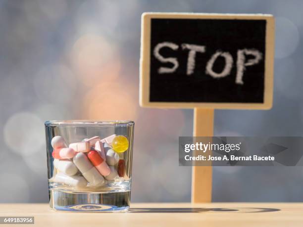 glass of crystal with an overdose of medicines i a sign with the stop sign , illuminated by the light of the sun - prozac stock pictures, royalty-free photos & images