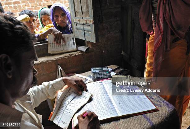 Indian men and women line up outside the Fair Price Shop with their ration cards to receive portions of wheat, sugar, kerosene and rice from the...