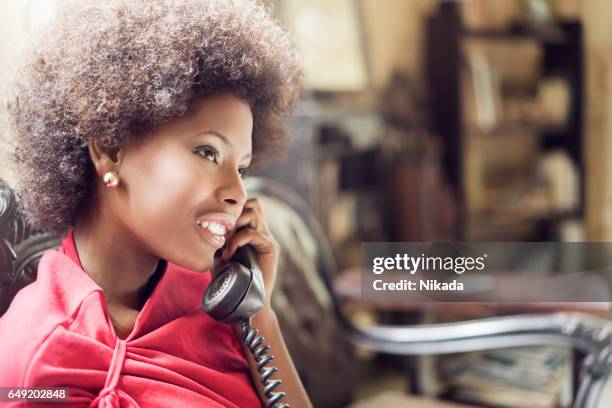 young woman using landline telephone - landline phone imagens e fotografias de stock