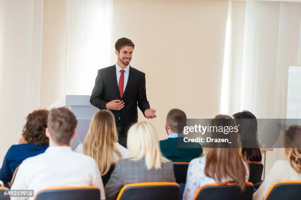 handsome businessman talking on plenary session in lecture hall - business plenary stock pictures, royalty-free photos & images