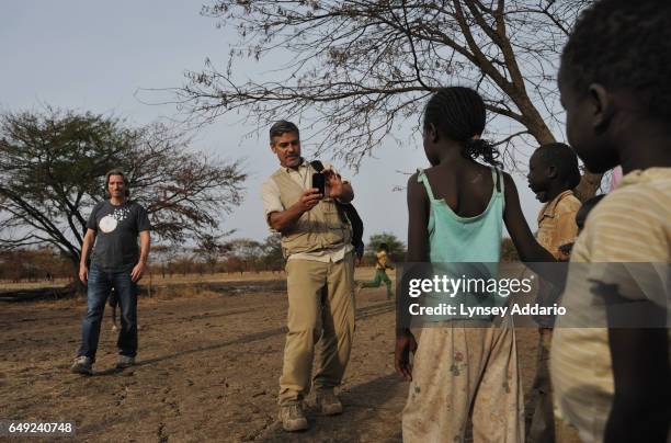 Actor George Clooney and American human rights activist John Prendergast walk through a camp for South Sudanese, returnees from North Sudan...