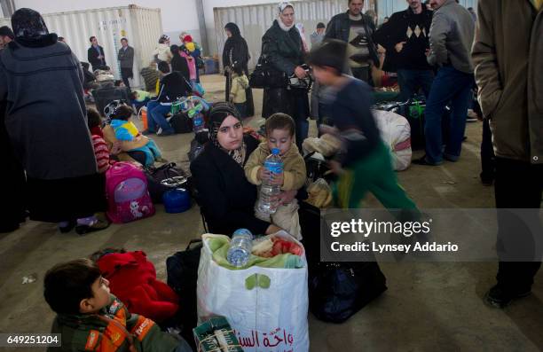 Syrian families sit with their luggage while waiting to board a ship to take them out of Benghazi, Libya, Monday, Feb. 28, 2011. Thousands of workers...