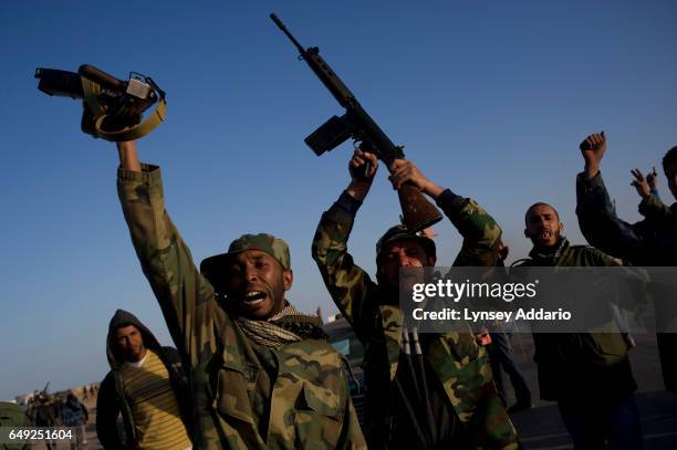 Opposition troops scream with rage, saying "Gaddafi is a murderer," moments after they are hit with an airstrike about 100 meters from an opposition...