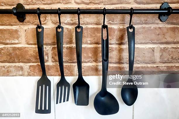 hanging kitchen untensils - mestolo foto e immagini stock