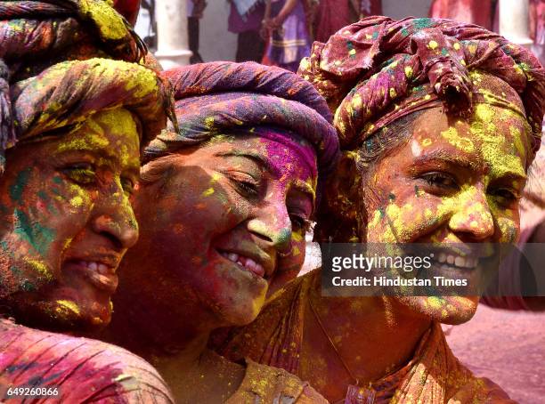 Indian villagers smear themselves with colours during the Lathmar Holi festival at the Nandji Temple on March 7, 2017 in Nandgaon near Mathura,...