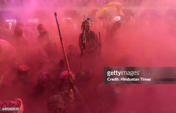 Indian villagers smear themselves with colours during the Lathmar Holi festival at the Nandji Temple on March 7, 2017 in Nandgaon near Mathura,...