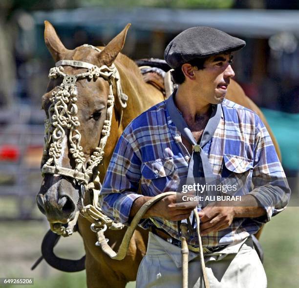 Horseman pulls his horse by the reins in Carmen de Areco City, in Buenos Aires province, Argentina, 25 January 2004. In the 'jineteadas' horsemen try...