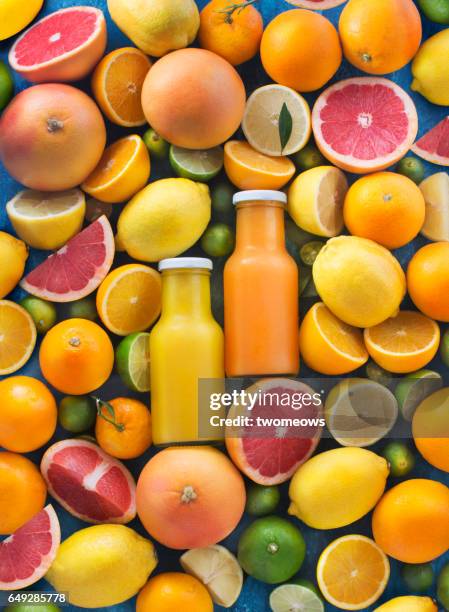 assorted citrus fruits and juice in bottles. - fruit juice stock pictures, royalty-free photos & images