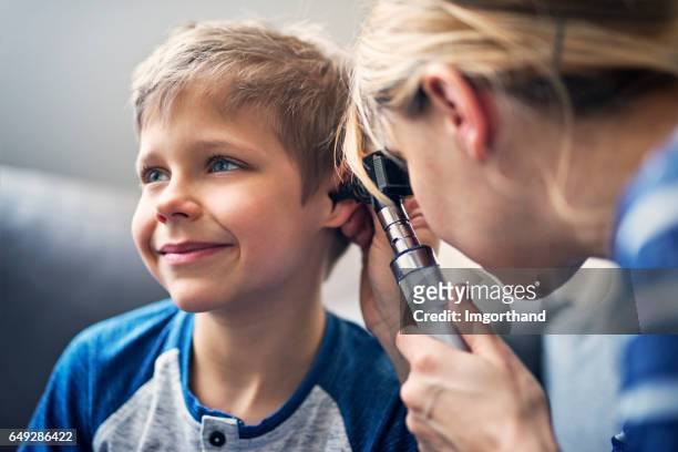 heureux petit garçon ayant l’examen de l’oreille - ears photos et images de collection