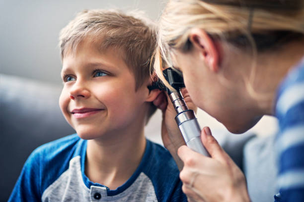 happy little boy having ear exam - ear nose and throat doctor stock pictures, royalty-free photos & images