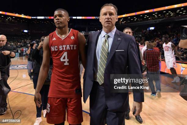 Dennis Smith Jr. #4 and head coach Mark Gottfried of the North Carolina State Wolfpack walk off the court following their 75-61 loss to the Clemson...