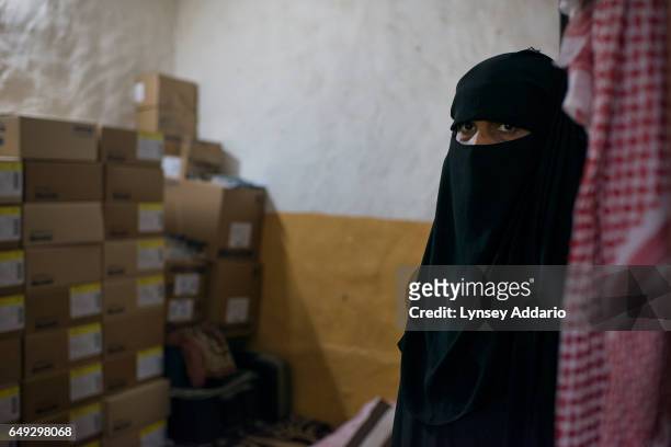 Fatima Hazazi stands in her home next to the boxes of medicine she requires every month to treat her kidney problem, in Riyadh, Saudi Arabia, March...