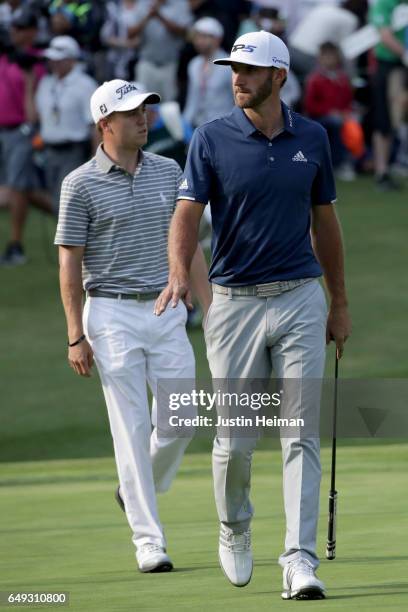 Dustin Johnson of the United States and Justin Thomas of the United States walks to the green on the 18th hole during the final round of the World...