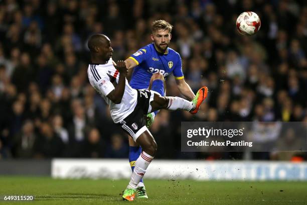 Sone Aluko of Fulham is tackled by Charlie Taylor of Leeds United during the Sky Bet Championship match between Fulham and Leeds United at Craven...