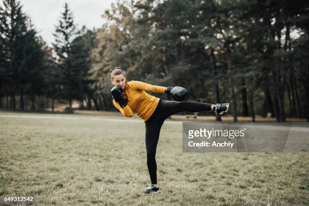 portrait of kickboxing woman doing a kick - high kick stock pictures, royalty-free photos & images