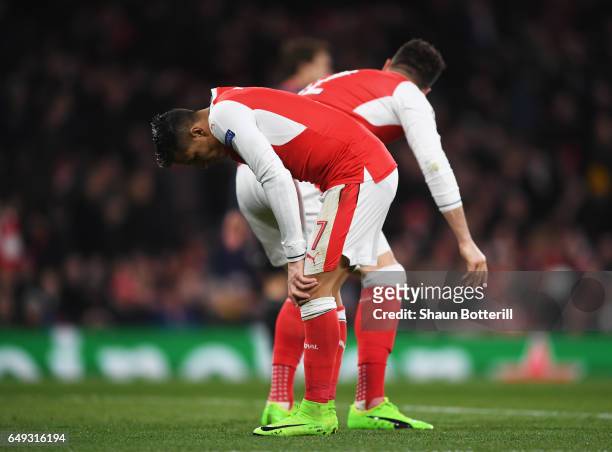 Alexis Sanchez and Olivier Giroud of Arsenal react during the UEFA Champions League Round of 16 second leg match between Arsenal FC and FC Bayern...