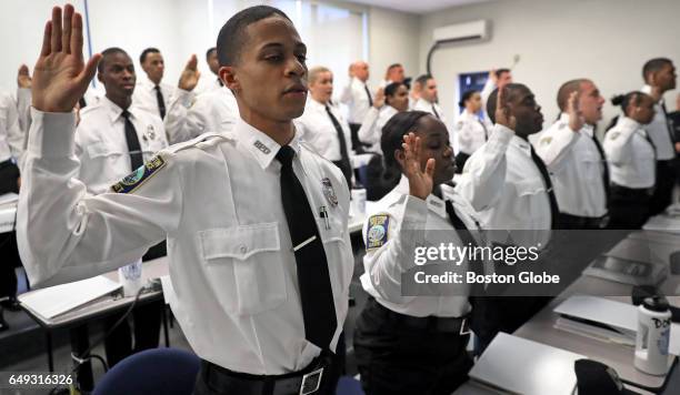 Cadet Jose Correia, far left, and other cadets are sworn in as Boston police cadets at the city's police academy in Boston on Nov. 16, 2016.