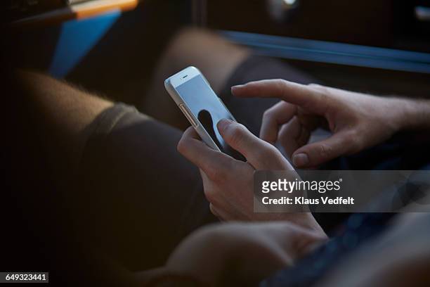 hands scrolling on smartphone, inside car - couple smartphone stockfoto's en -beelden