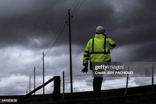 Employees of French national electricity grid company Enedis work to repair high voltage lines on March 7 near Amplepuis, central France, after the...