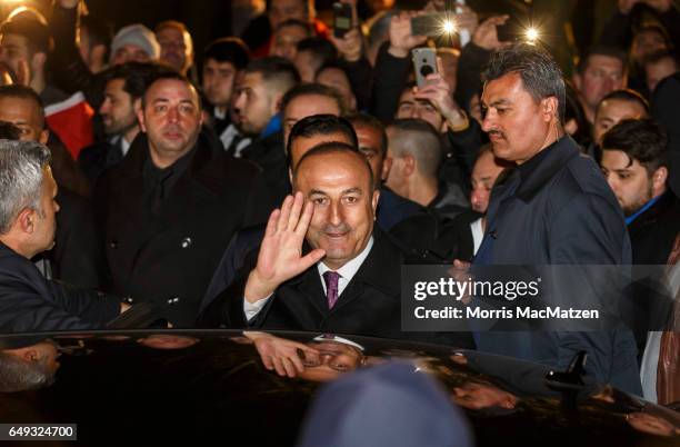 Turkish Foreign Minister Mevlut Cavusoglu emerges from the Turkish consulate after speaking to supporters of the upcoming referendum in Turkey on...