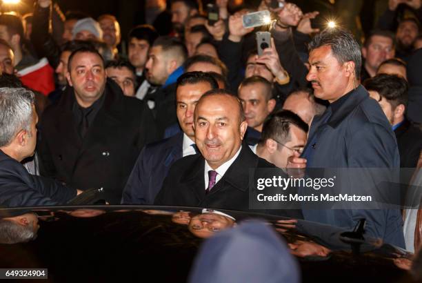 Turkish Foreign Minister Mevlut Cavusoglu emerges from the Turkish consulate after speaking to supporters of the upcoming referendum in Turkey on...