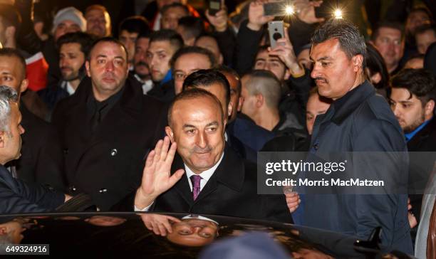 Turkish Foreign Minister Mevlut Cavusoglu emerges from the Turkish consulate after speaking to supporters of the upcoming referendum in Turkey on...