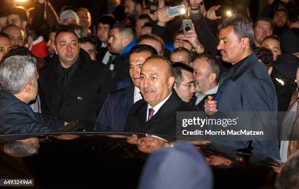 Turkish Foreign Minister Mevlut Cavusoglu emerges from the Turkish consulate after speaking to supporters of the upcoming referendum in Turkey on...