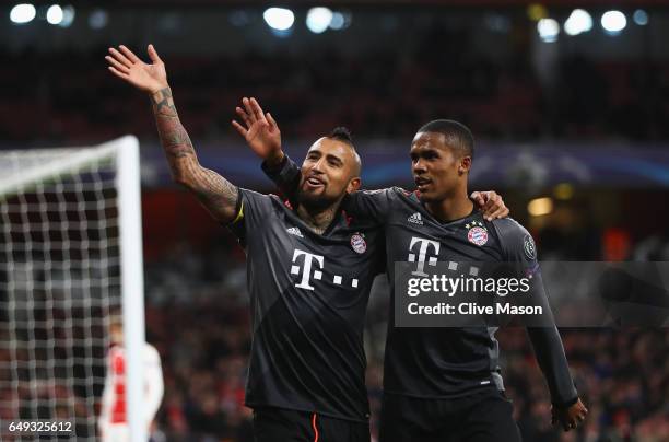 Arturo Vidal of Bayern Muenchen celebrates with Douglas Costa as he scores their fifth goal during the UEFA Champions League Round of 16 second leg...