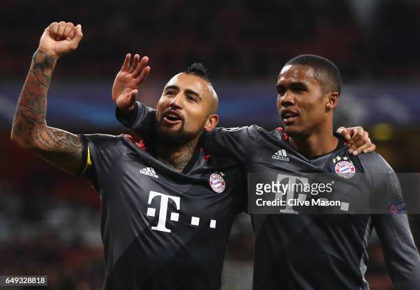 Arturo Vidal of Bayern Muenchen celebrates with Douglas Costa as he scores their fifth goal during the UEFA Champions League Round of 16 second leg...
