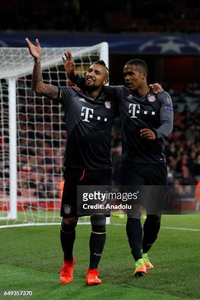 Bayern Munich's Arturo Vidal and Bayern Munich's Douglas Costa celebrate after a goal during the UEFA Champions League match between Arsenal FC and...
