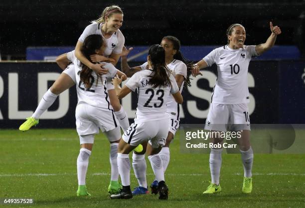 Eugenie Le Sommer of France jumps into the arms of teammates after scoring the second goal in the first half of their match against the United States...