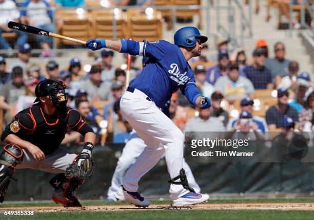 Adrian Gonzalez of the Los Angeles Dodgers singles in the first inning against the San Francisco Giants during the spring training game at Camelback...