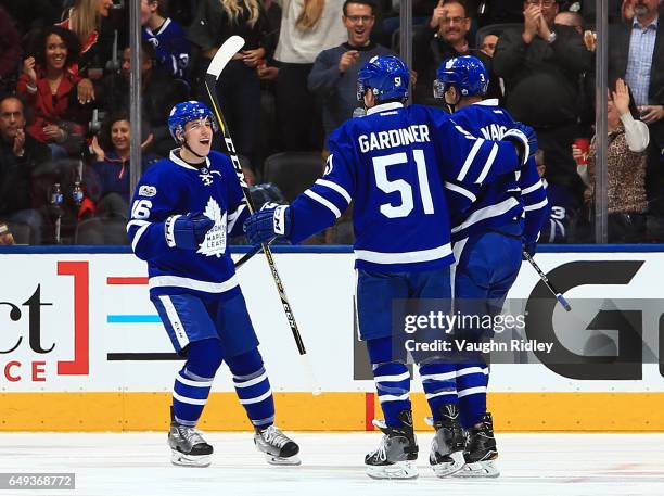 Mitchell Marner and Jake Gardiner of the Toronto Maple Leafs celebrate a goal by Alexey Marchenko during an NHL game against the Detroit Red Wings at...