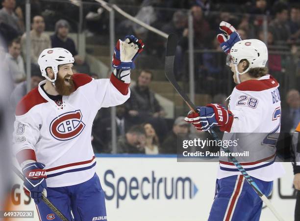 Jordie Benn of the Montreal Canadiens celebrates scoring a goal with Nathan Beaulieu in an NHL hockey game against the New York Rangers at Madison...