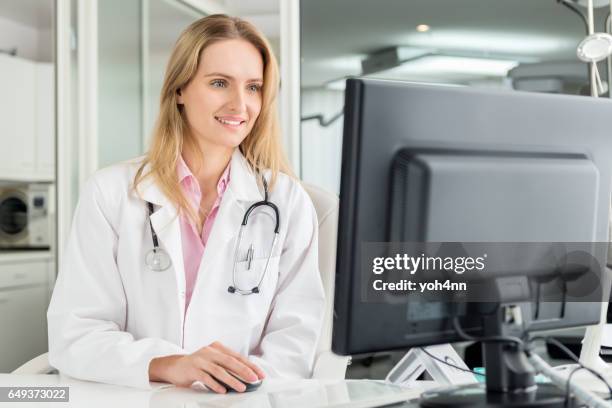 doctor sitting at desk & using computer - electronic medical record stock pictures, royalty-free photos & images